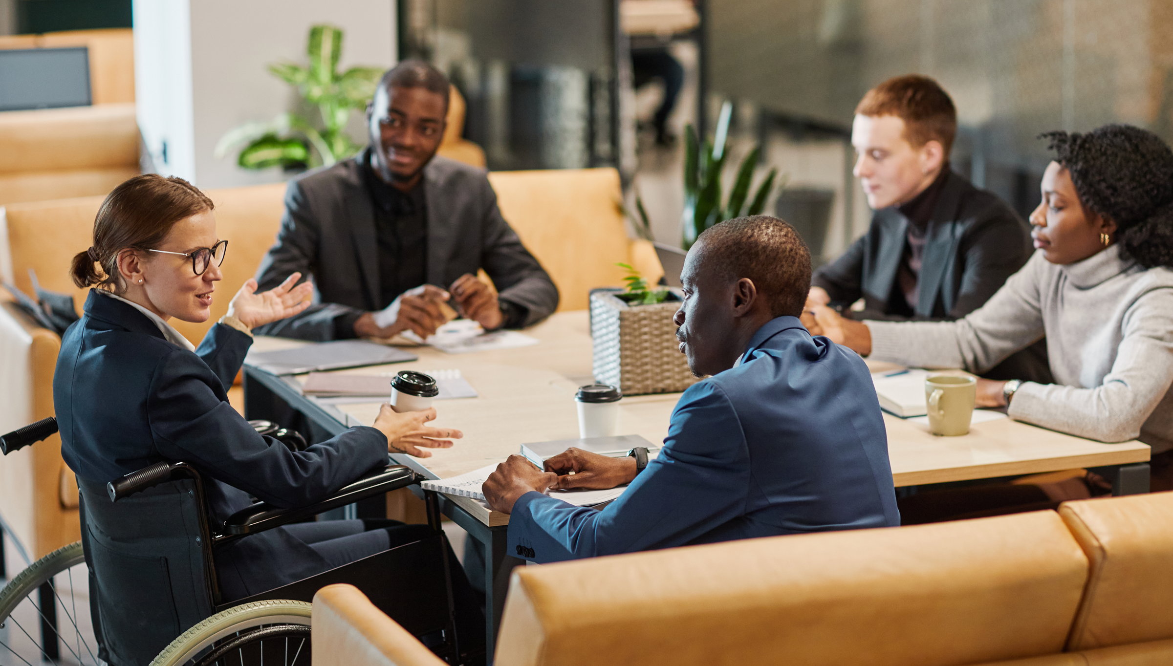 Woman in a wheelchair speaking with a team of personal injury lawyers